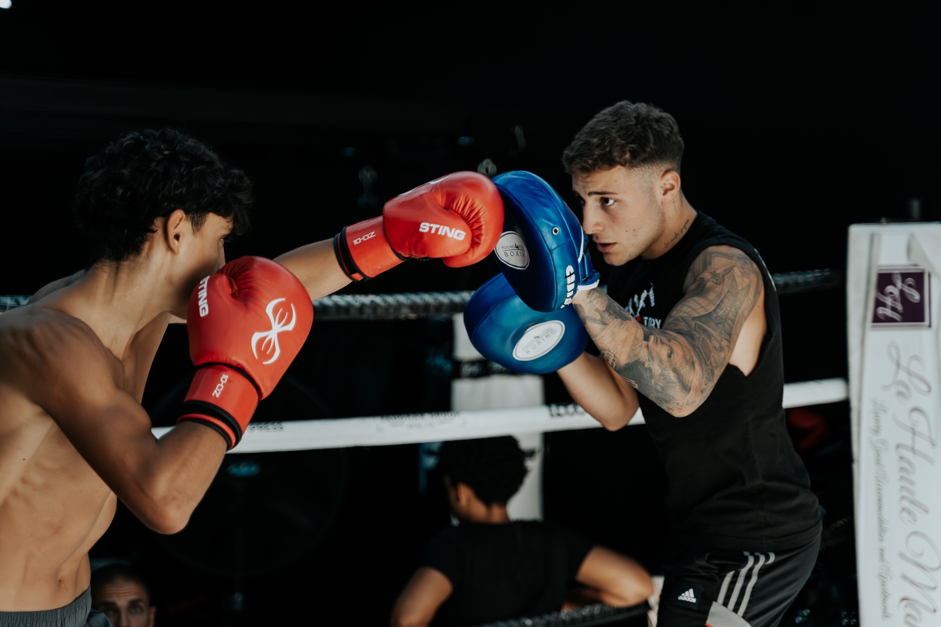Coach holding punch pads for a fighter during a private boxing session
