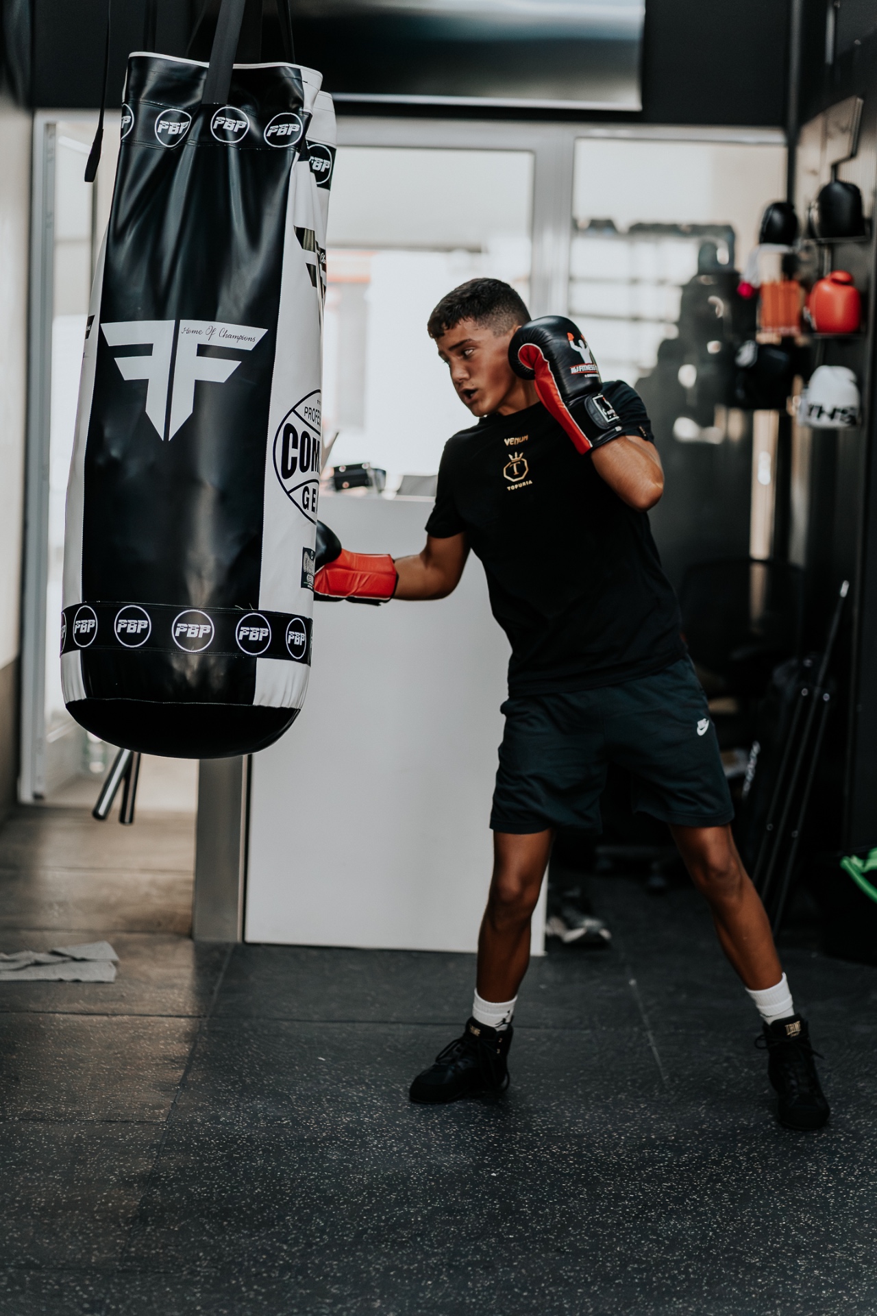 Young boxer working the Fight Factory heavy bag during a boxing class