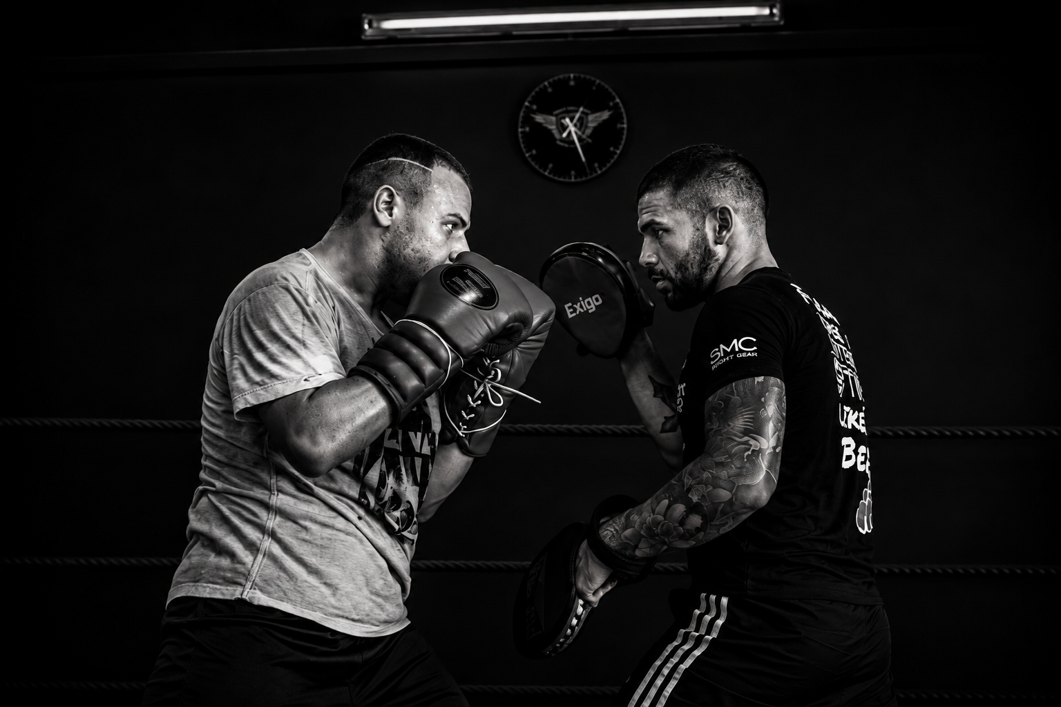 Coach holding pads for a fighter in the ring at Fight Factory